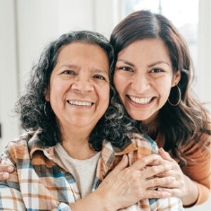 front facing image of middle-aged adult woman with grandmother smiling and hugging